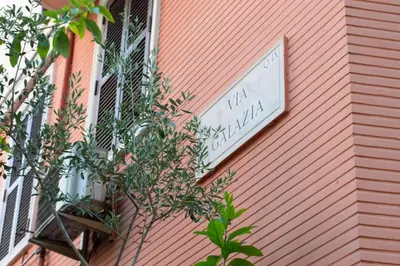 a sign on the side of a pink building at Appartamento di Charme San Giovanni - Colosseo in Rome