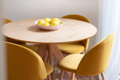 a bowl of fruit on a wooden table with yellow chairs at Appartamento di Charme San Giovanni - Colosseo in Rome