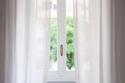 a window with white curtains in a room at Appartamento di Charme San Giovanni - Colosseo in Rome