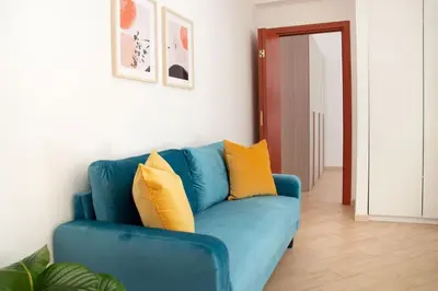 a blue couch with yellow pillows in a living room at Esclusivo Appartamento di design (metro Tiburtina) in Rome