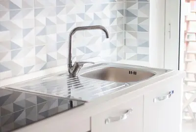 a sink in a bathroom with blue and white tiles at Esclusivo Appartamento di design (metro Tiburtina) in Rome