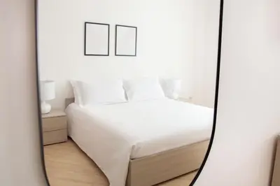a bedroom with a white bed and two framed pictures at Esclusivo Appartamento di design (metro Tiburtina) in Rome
