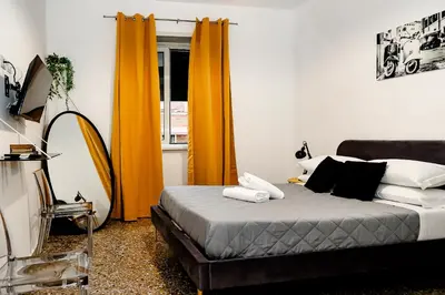 a bedroom with a bed with orange curtains and a mirror at MyWay RDR in Rome