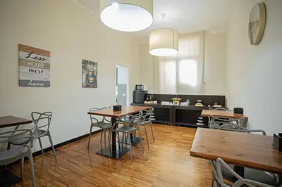 a room with tables and chairs and a kitchen at OperaDreams2 in Rome