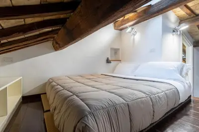 a large bed in a room with wooden ceilings at The Attico: best view of Rome in Rome