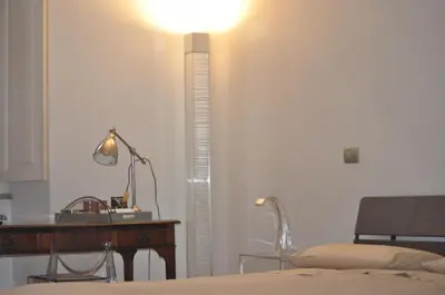 a bedroom with a desk and a bed and a lamp at A casa di Pelé suite in Rome