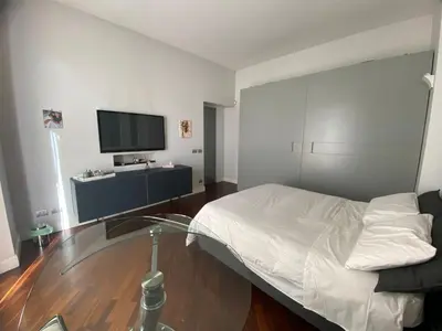 a bedroom with a bed and a tv on the wall at A casa di Pele in Rome