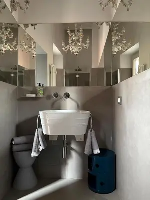a bathroom with a sink and a toilet and mirrors at Monti Art Loft in Rome