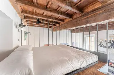 a large bed in a room with wooden ceilings at Monti Art Loft in Rome