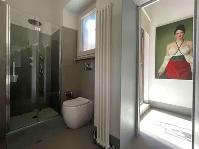 a bathroom with a shower and a painting of a woman at Monti Art Loft in Rome