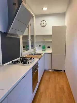 a kitchen with a stove and a clock on the wall at In Città- appartamento a Roma con terrazzo in Rome