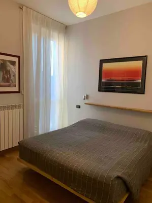 a bedroom with a bed and a large window at In Città- appartamento a Roma con terrazzo in Rome