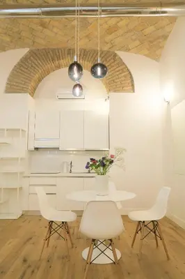 a white kitchen with a table and chairs at Via Veneto Luxury Loft in Rome