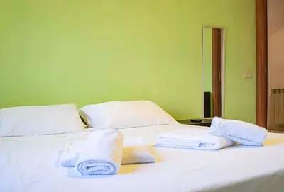 a large white bed with towels on top of it at Hostme Luminoso Appartamento Metro Marconi in Rome
