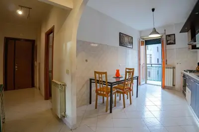 a dining room with a table and chairs in a kitchen at Hostme Luminoso Appartamento Metro Marconi in Rome