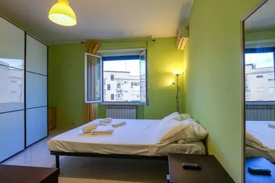 a small room with a bed and two windows at Hostme Luminoso Appartamento Metro Marconi in Rome