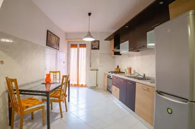 a kitchen with a table and chairs and a refrigerator at Hostme Luminoso Appartamento Metro Marconi in Rome