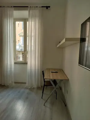 a table and a chair in a room with a window at ViviRome - 2 Bedrooms Apartment - San Giovanni in Rome