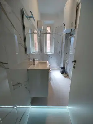 a white bathroom with a sink and a mirror at ViviRome - 2 Bedrooms Apartment - San Giovanni in Rome