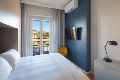 a bedroom with a white bed and a window at Migliori Collection Penthouse in Rome