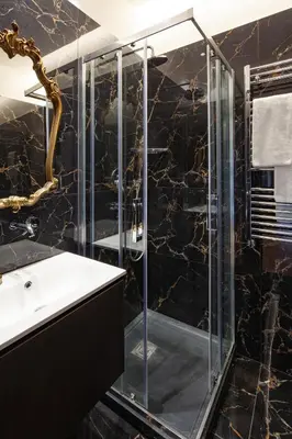 a bathroom with a glass shower and a sink at Migliori Collection Penthouse in Rome