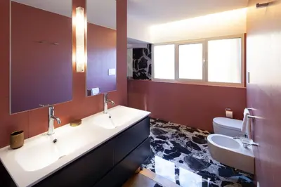 a bathroom with two sinks and a toilet at Migliori Collection Penthouse in Rome
