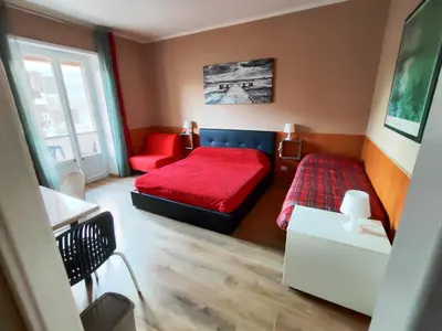 a bedroom with a red bed and a red couch at B&B Bella Garbatella in Rome
