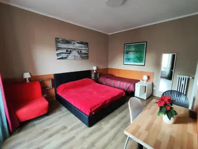 a bedroom with a red bed and a table at B&B Bella Garbatella in Rome