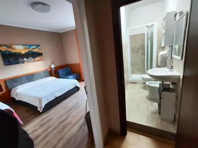 a bedroom with a bed and a bathroom with a sink at B&B Bella Garbatella in Rome