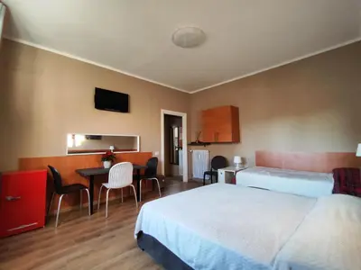 a hotel room with two beds and a table and chairs at B&B Bella Garbatella in Rome