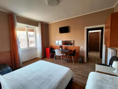 a hotel room with two beds and a table and chairs at B&B Bella Garbatella in Rome