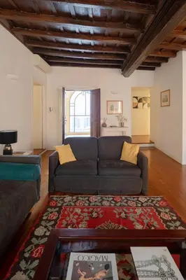 a living room with a couch and a rug at Elegante rifugio in centro storico Roma tra Piazza del Popolo e Piazza di Spagna in Rome