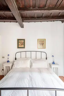 a bedroom with a white bed with two tables at Elegante rifugio in centro storico Roma tra Piazza del Popolo e Piazza di Spagna in Rome