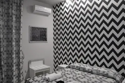 a bedroom with a bed and a checkered wall at Il Corso Suite in Rome