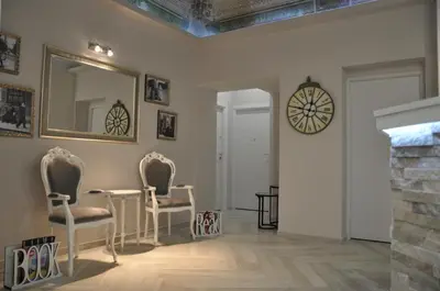 a living room with a table and chairs and a clock at Il Corso Suite in Rome