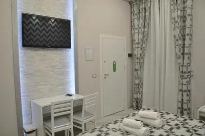 a bedroom with a bed and a table and a door at Il Corso Suite in Rome
