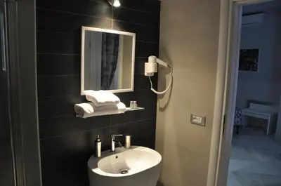 a bathroom with a sink and a mirror at Il Corso Suite in Rome