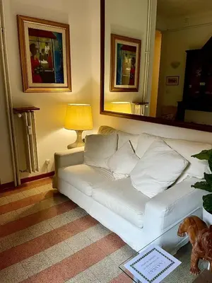 a white couch in a living room with a lamp at Casa Vasari in Rome