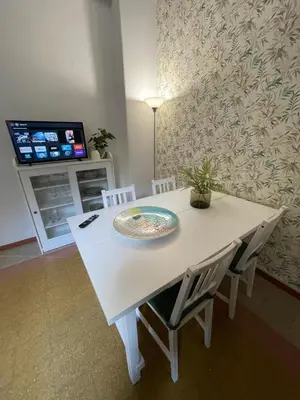 a white dining room table with chairs and a tv at Casa Vasari in Rome