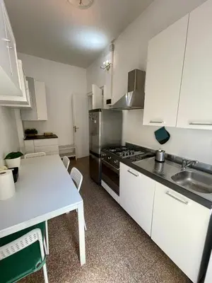 a kitchen with white cabinets and a table and a sink at Casa Vasari in Rome