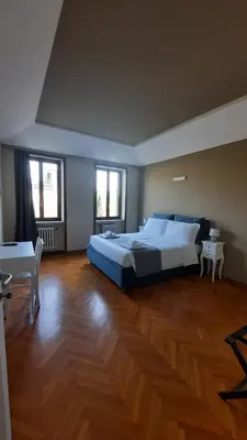 a large bedroom with a large bed and wooden floors at Relais La Fornarina 2 in Rome