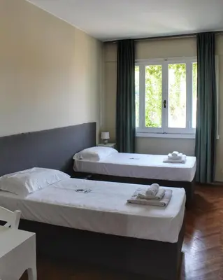 a bedroom with two beds and a window at Relais La Fornarina 2 in Rome
