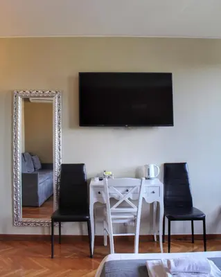 a living room with a table with two chairs and a mirror at Relais La Fornarina 2 in Rome