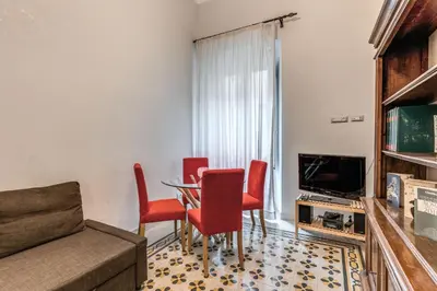 a living room with a table and red chairs at Montebello Apartments79 in Rome