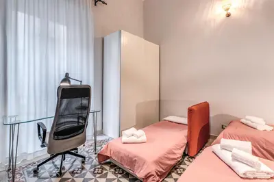 a room with two beds and a chair and a mirror at Montebello Apartments79 in Rome