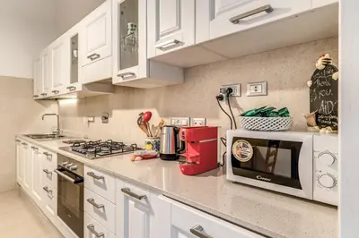 a kitchen with white cabinets and a stove top oven at Montebello Apartments79 in Rome