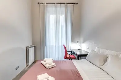 a bedroom with a bed with a desk and a window at Montebello Apartments79 in Rome