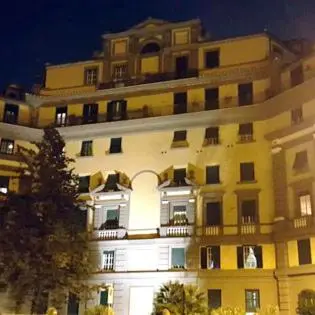 a large yellow building with a lot of windows at Deromatality Vaticano Piazza di Spagna Colosseo in Rome