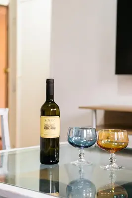 a bottle of wine and two glasses on a table at Aurelia Deluxe Suites in Rome