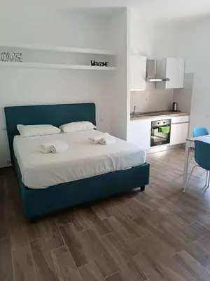 a bedroom with a bed and a kitchen and a table at Aurelia Deluxe Suites in Rome